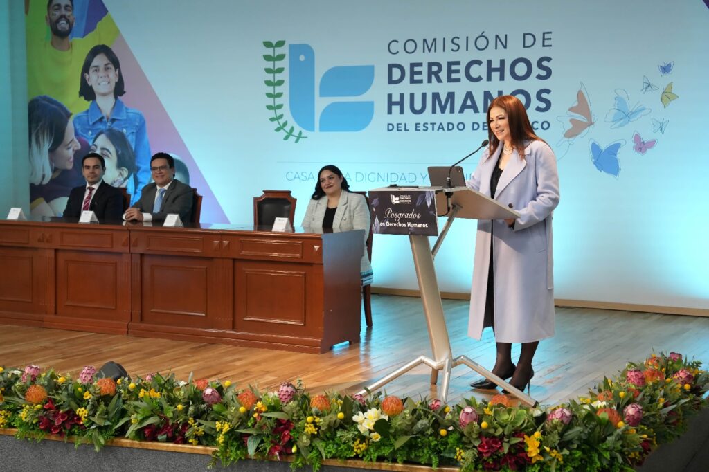 La presidenta de la CODHEM, Myrna Araceli García Morón, entrega reconocimiento a egresados de la Maestría en Derechos Humanos y Emergentes, durante la ceremonia de clausura en Toluca.