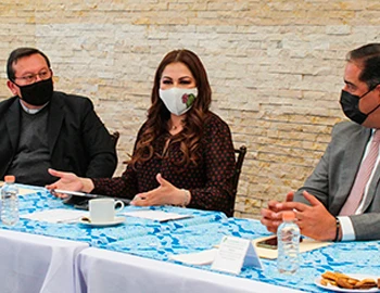 LA LIBERTAD RELIGIOSA ES IGUAL DE IMPORTANTE QUE LAS DEMÁS, COINCIDEN LA CODHEM Y EL CONSEJO INTERRELIGIOSO DEL EDOMEX. Imagen de una reunión institucional con tres personas sentadas alrededor de una mesa, usando cubrebocas, con documentos y material de trabajo visibles.