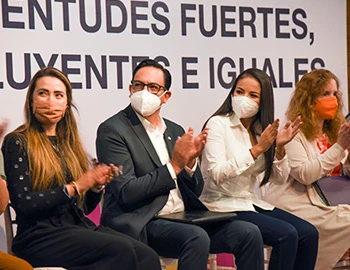 Imagen de personas sentadas en un evento público, aplaudiendo frente a un mensaje sobre juventudes, utilizada para destacar la importancia de escuchar a las nuevas generaciones para transformar la sociedad.