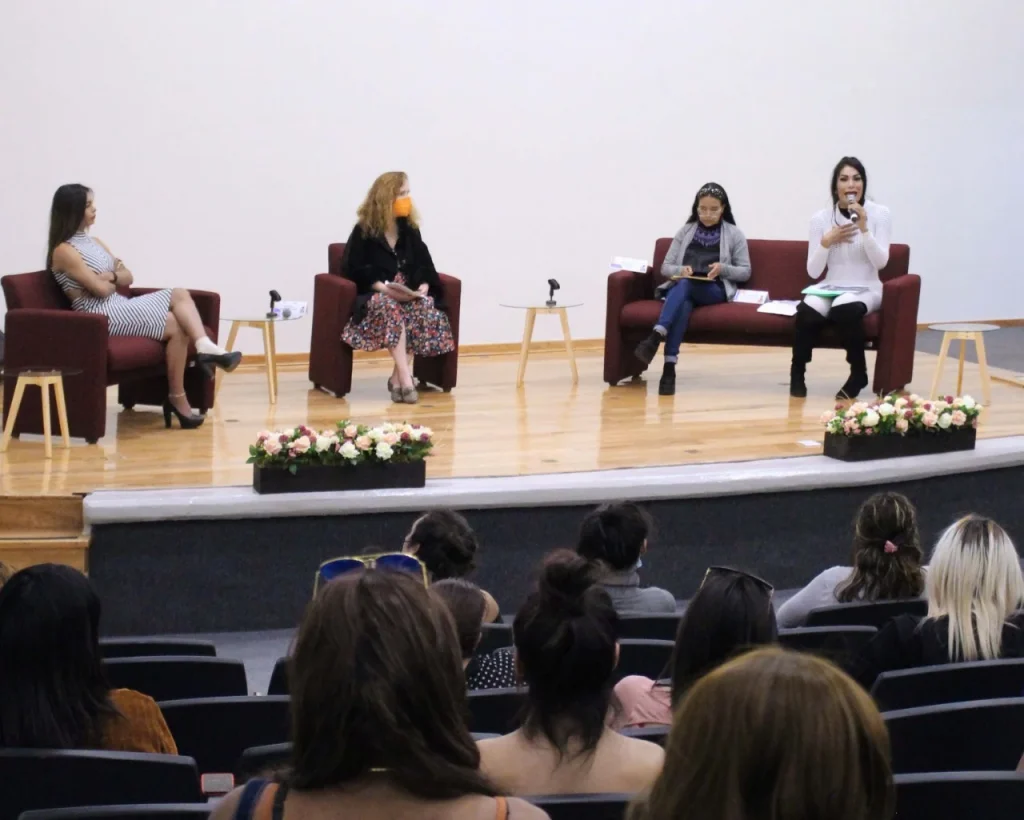 Panel de diálogo en un auditorio con personas participantes sentadas en el escenario y público asistente. CODHEM LLAMA A RESPETAR LOS DERECHOS HUMANOS DE MUJERES TRANS.