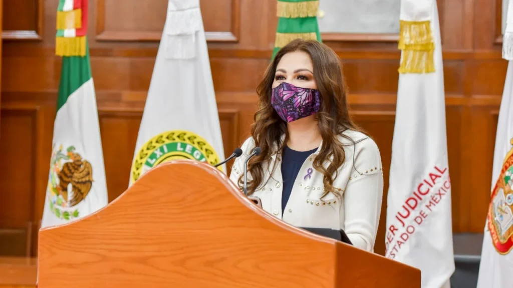 Persona de pie en un recinto legislativo, frente a un podio y banderas oficiales. La titular del organismo defensor Myrna Araceli García Morón participó en el Primer Foro organizado en la legislatura local previo a la conmemoración del 8 de marzo.