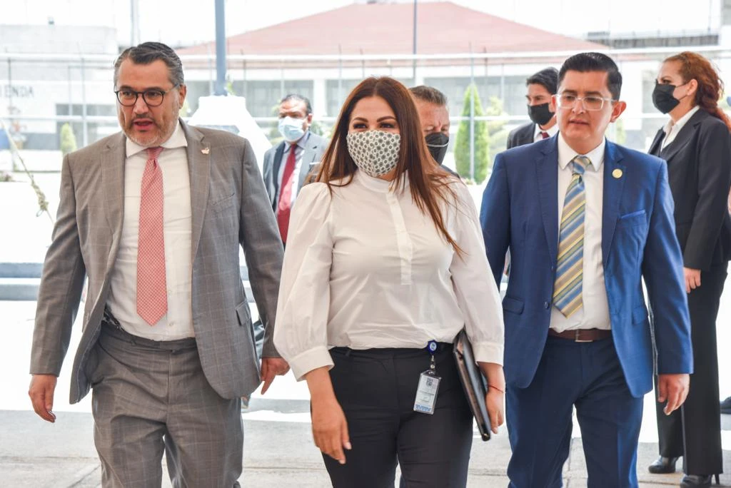 FIRMAN CONVENIO LA CODHEM Y LA SECRETARÍA DE SEGURIDAD PARA INSTALAR BUZONES DE QUEJAS EN LOS CENTROS PENITENCIARIOS. Imagen de una comitiva institucional caminando en un edificio, durante un acto oficial relacionado con seguridad y derechos humanos.