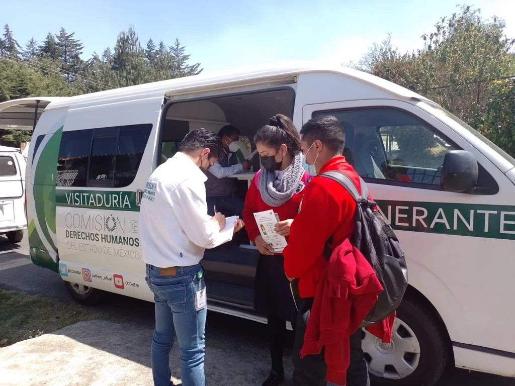 VISITADURÍA ITINERANTE DE LA CODHEM BRINDÓ 293 ASESORÍAS JURÍDICAS A LOS HABITANTES DE 24 MUNICIPIOS. Imagen de personal de la CODHEM brindando orientación y recibiendo documentación de personas usuarias junto a una unidad móvil institucional.