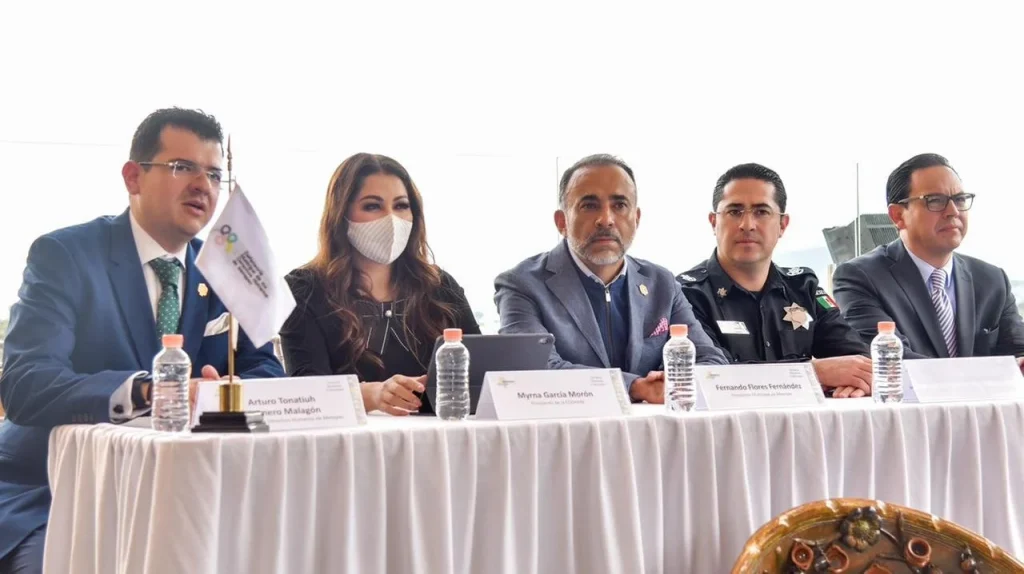 Personas funcionarias sentadas en una mesa durante un acto institucional de colaboración entre la CODHEM y el municipio de Metepec para fortalecer el bienestar social.