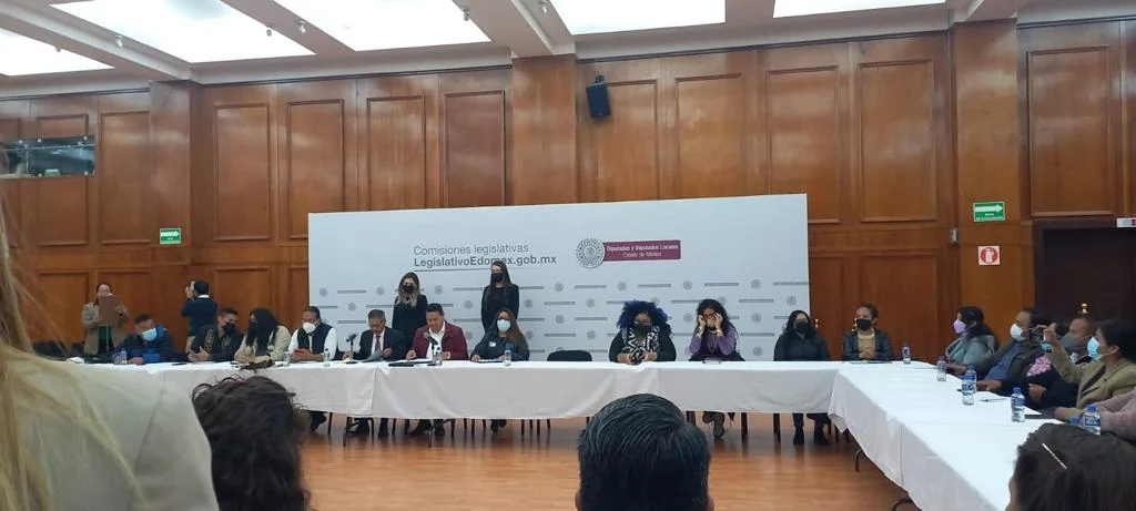 Personas participantes sentadas alrededor de una mesa en una sesión legislativa sobre el reconocimiento constitucional de los pueblos y comunidades afromexicanas.