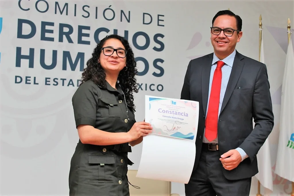 Personas conversan en un espacio institucional de la CODHEM durante un diálogo sobre un libro de poesía que aborda la discapacidad psicosocial y la importancia del goce de los derechos humanos.