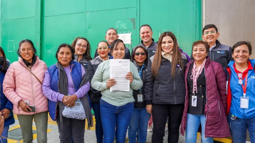 Grupo de personas en vía pública; una persona al centro sostiene un documento oficial, acompañada por personal institucional. Se emite pronunciamiento de amnistía tras vulneración de derechos y se destaca una segunda oportunidad mediante apoyo institucional.