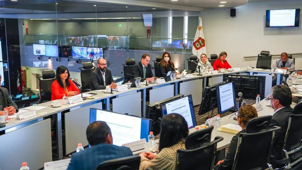 Personas en mesa de reunión institucional con micrófonos y documentos frente a pantallas; CODHEM destaca la importancia de conocer el protocolo de actuación para garantizar derechos de periodistas.