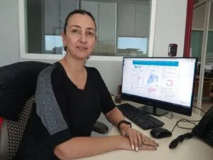 Persona sentada en oficina frente a una computadora que muestra gráficas estadísticas; la CODHEM promueve la transparencia proactiva al difundir datos sobre quejas y capacitación.