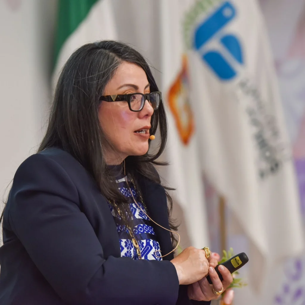 Persona con gafas y micrófono ofrece una ponencia; destacó que la perspectiva de género puede mejorar la vida y promover igualdad en beneficio social, afirmó la magistrada Julia María del Carmen García González.