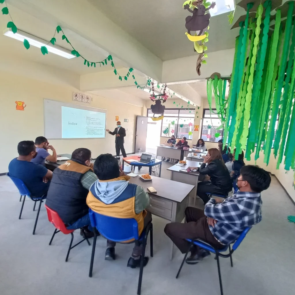 Grupo de docentes recibe capacitación en aula mientras una persona expositora presenta material en pantalla, como parte de las acciones de CODHEM para atender quejas y fortalecer la formación del personal educativo.