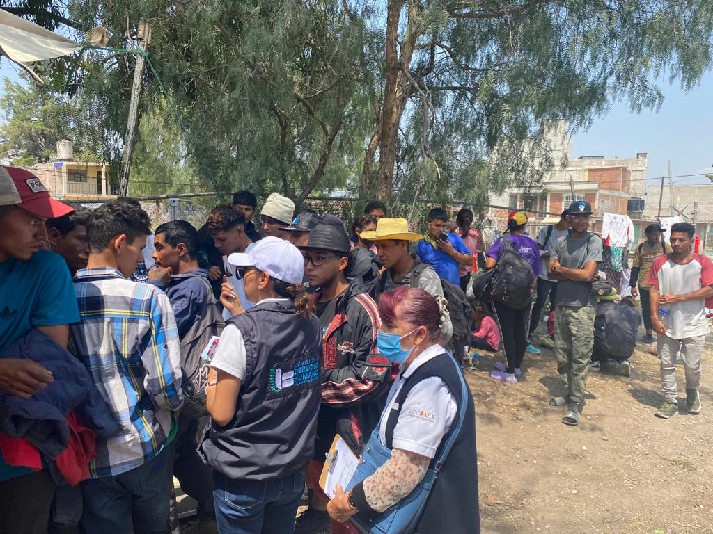 Personas migrantes reciben atención y orientación por personal de la CODHEM y el INM durante jornada en Huehuetoca, en espacio abierto con registro y revisión de documentos.