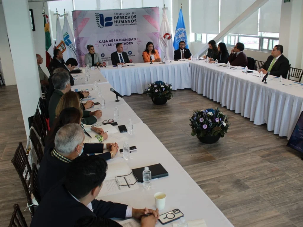 Reunión de trabajo de la CODHEM con diversas personas participantes alrededor de una mesa, durante la construcción de un protocolo con perspectiva ambiental, con fondo institucional de la Comisión de Derechos Humanos del Estado de México.