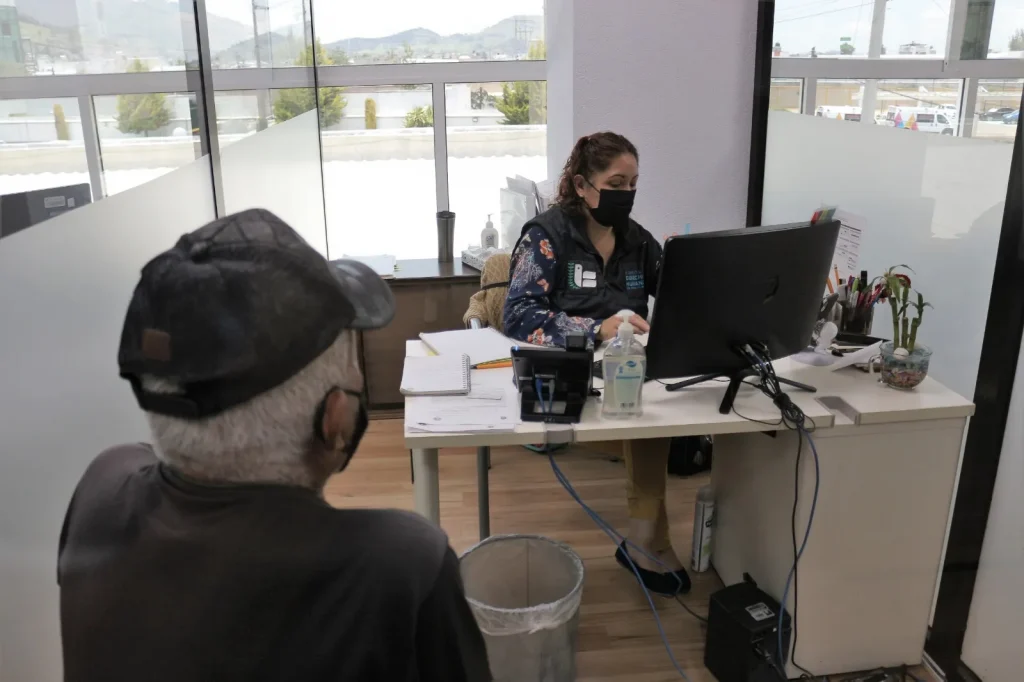 Persona usuaria es atendida en un módulo de la CODHEM por personal frente a computadora en oficina, ilustrando la recepción de quejas presentadas durante el primer semestre de 2023.
