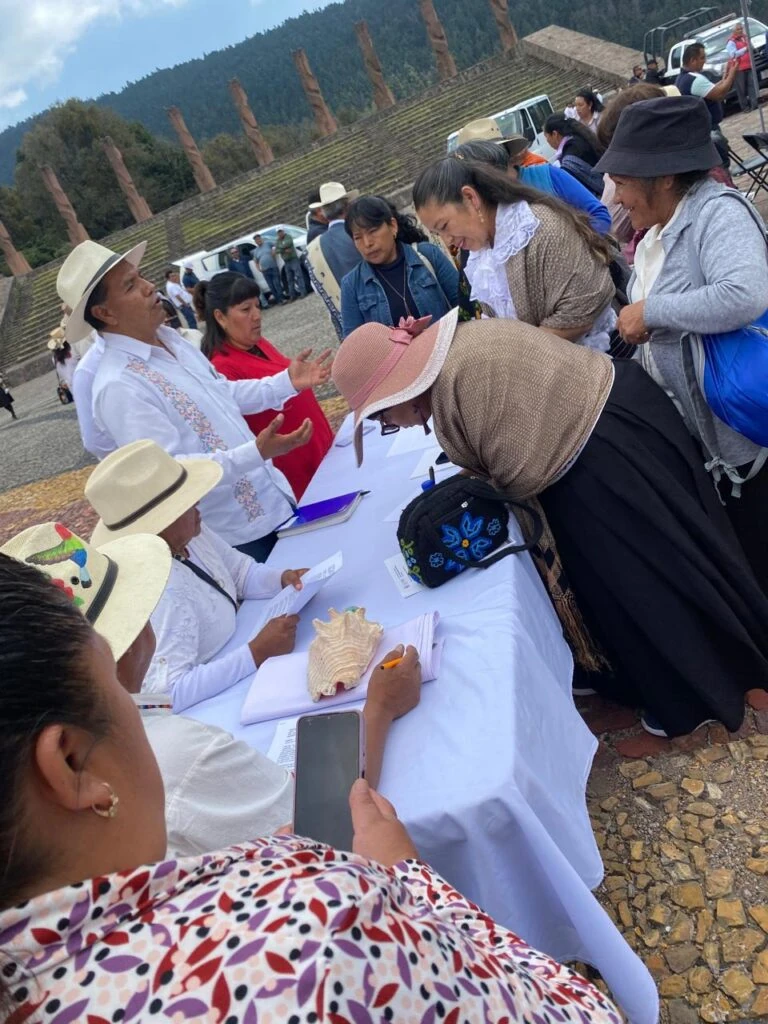 Personas integrantes de comunidades indígenas participan en una mesa de registro y diálogo al aire libre, durante un encuentro enfocado en la representación, la participación comunitaria y el ejercicio de los derechos colectivos.
