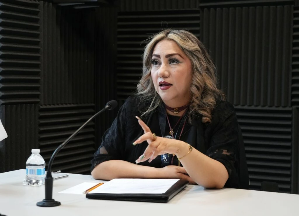 Primer plano de una persona durante una entrevista en un estudio de grabación de la CODHEM, realizando una intervención frente a un micrófono. La fotografía ilustra la difusión del mensaje de Sandra Tetatzin Contreras sobre el impulso de estrategias de atención contra la discriminación múltiple.